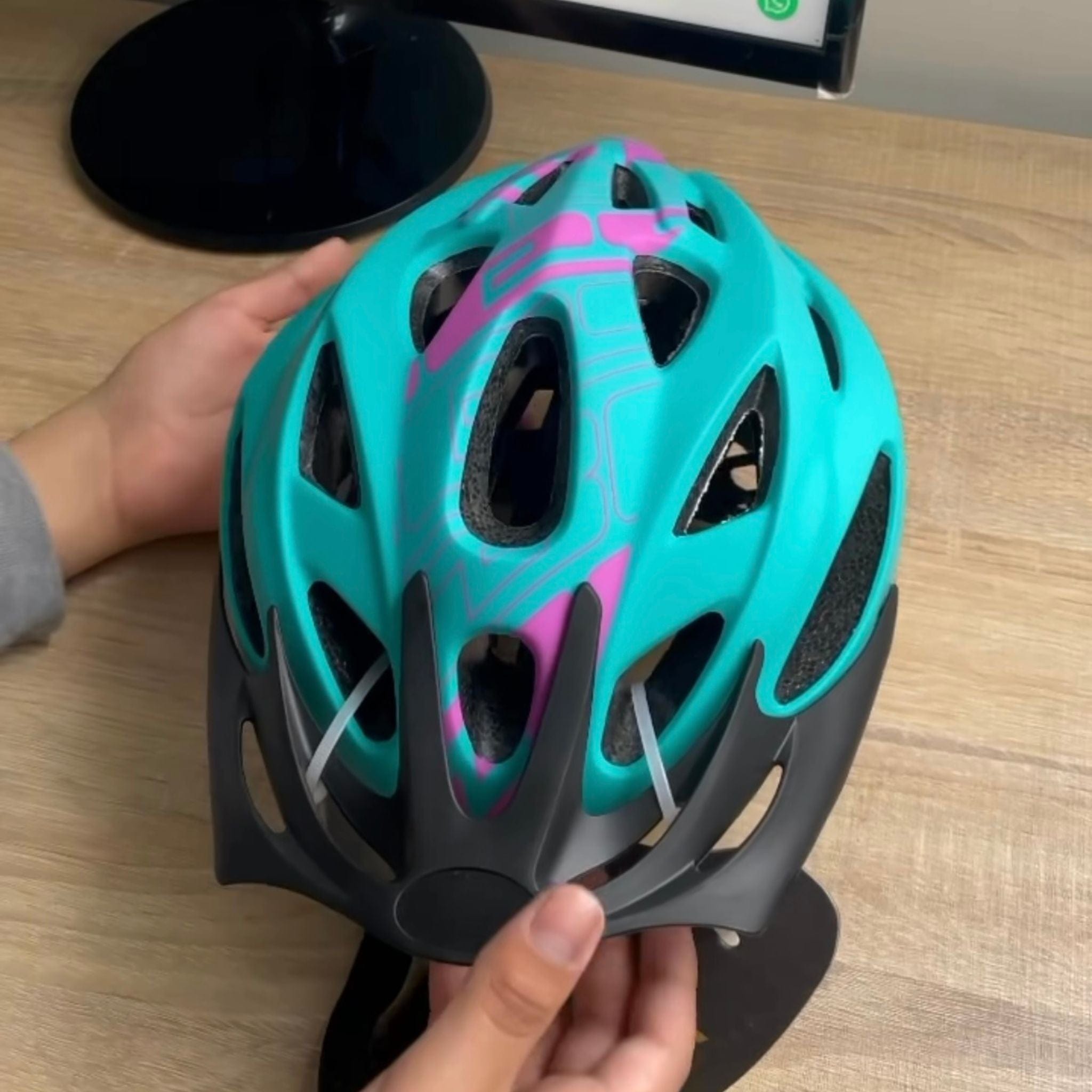 Persona mostrando un casco de ciclismo Crest en colores turquesa y morado con diseño aerodinámico y ventilación eficiente