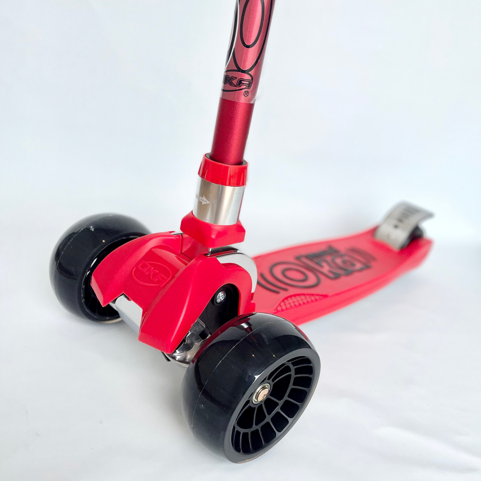 Ruedas delanteras del scooter rojo de tres ruedas OKA para niños de 5 a 12 años. Estructura duradera y manillar ajustable.